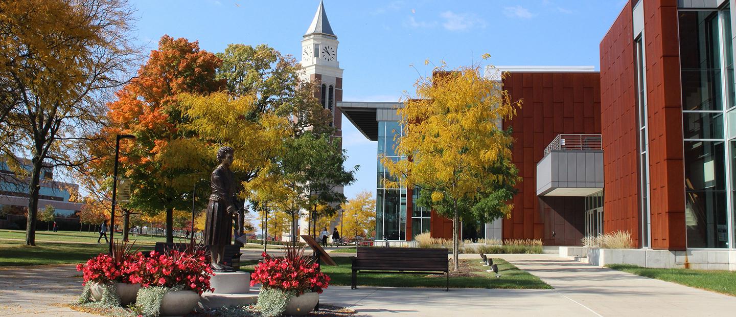 Oakland University campus in fall, with the Elliott Tower and a statue of Matilda Dodge Wilson.